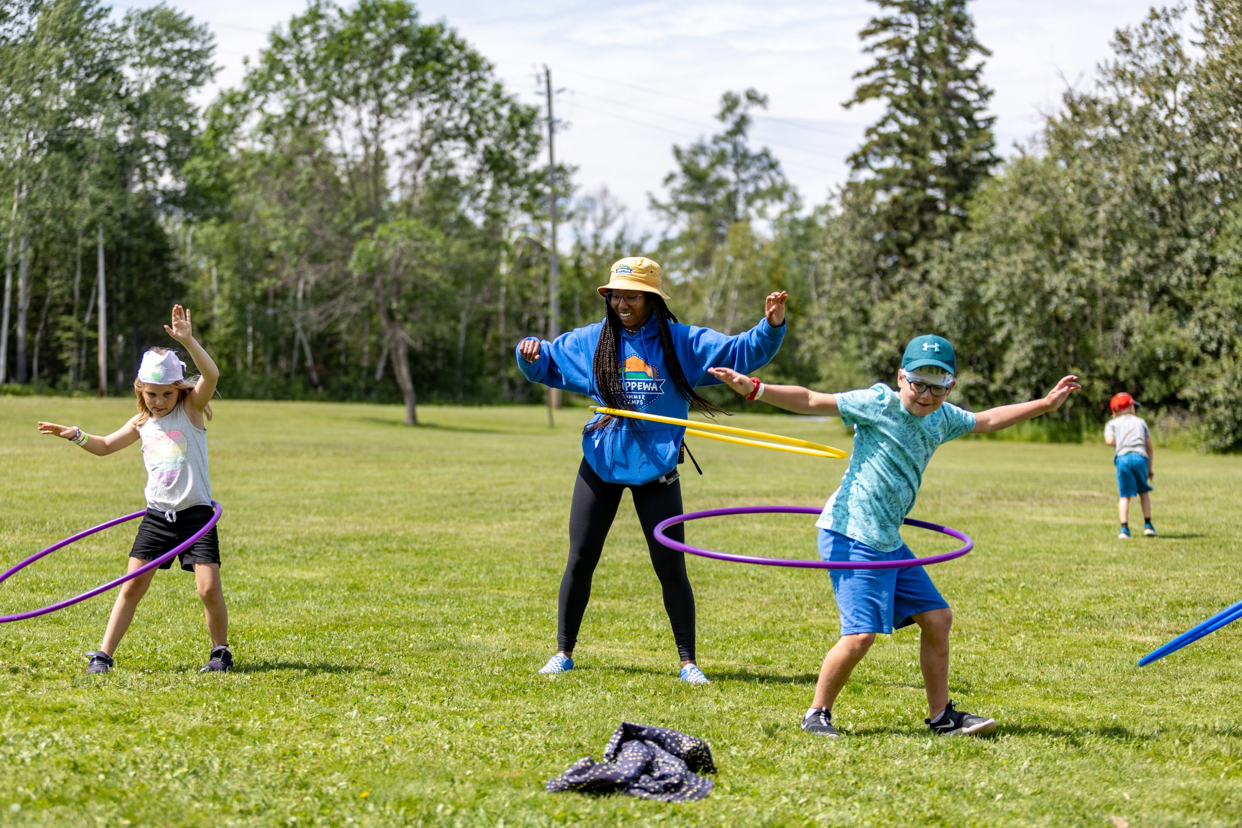 Chippewa staff and participants playing hula-hoop outside.